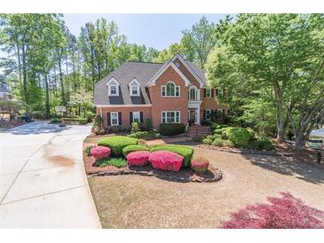 Beautiful two-story brick home with lush landscaping and a well-manicured lawn at 860 Cramac Dr, Lawrenceville, GA 30046