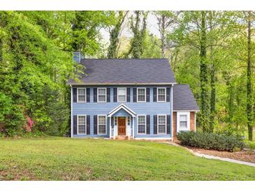 Charming two-story home with a blue exterior, black shutters, and a well-maintained front lawn at 1972 Tanglewood Dr, Snellville, GA 30078
