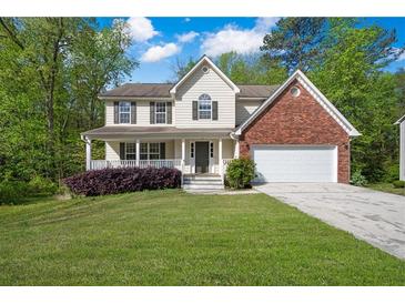 Charming two-story traditional home featuring a manicured front yard and a brick-accented attached two-car garage at 2979 Sweetbriar Walk, Snellville, GA 30039