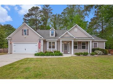 Charming single-story home featuring a manicured lawn, attached garage, and covered front porch at 4960 Shannon Sw Way, Mableton, GA 30126