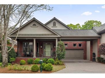 Charming brick home featuring a covered front porch, portico, and well-manicured landscaping at 1061 Arbor Ne Trce, Atlanta, GA 30319