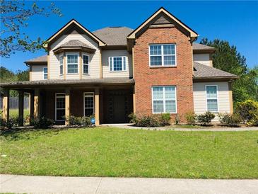 Inviting two-story home showcasing brick and tan siding, complete with a well-manicured lawn and covered porch at 533 Mount Gerizim Se Rd, Mableton, GA 30126