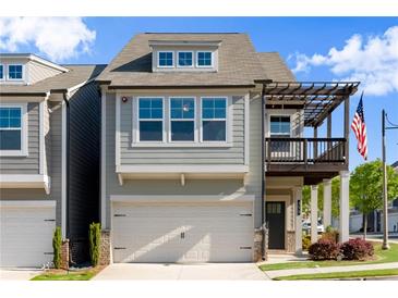 Charming two-story home featuring a front-facing garage, a quaint second-story balcony, and an American flag at 350 Hayden Cir, Woodstock, GA 30189