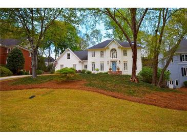 Charming white brick home with a well-manicured lawn and mature trees at 914 Denmeade Sw Walk, Marietta, GA 30064