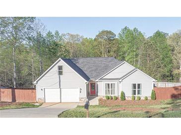 Charming one-story home with gray siding, an attached garage, a well manicured lawn and a red front door at 191 Fairview Oak Trl, Dallas, GA 30157