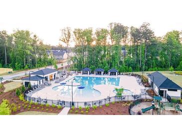 Beautiful community pool with cabanas, a playground, and lounge chairs surrounded by a tree-lined landscape at 600 Silver Moon Dr, Loganville, GA 30052