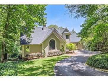 Charming home with a well-manicured lawn, mature trees, and a welcoming driveway at 1872 Lake Lucerne Sw Dr, Lilburn, GA 30047