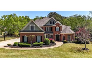 Stately brick home with manicured lawn and mature trees showcases curb appeal at 222 Rippling Nw Dr, Marietta, GA 30064