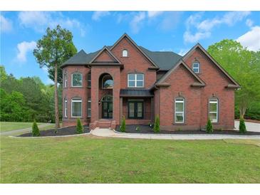 Stately brick home with manicured lawn and mature trees offering classic curb appeal at 6048 Golf View Xing, Locust Grove, GA 30248