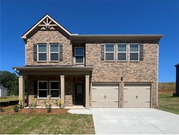 Beautiful two-story brick home featuring a two-car garage and covered front porch at 663 Egrets Landing Lot #55, Covington, GA 30014