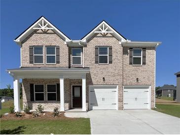 Charming two-story brick home with a two-car garage, covered entryway, and dark shutters at 669 Egrets Lot 56 Lndg, Covington, GA 30014