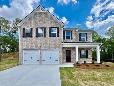 Charming two-story brick home featuring a two-car garage and inviting front porch at 679 Egrets Landing Lot 57, Covington, GA 30014