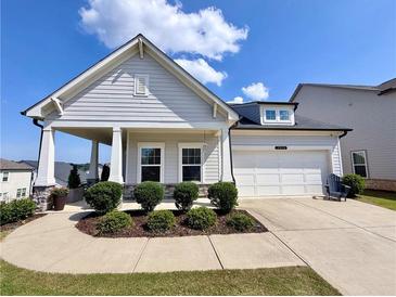 Charming home with a two-car garage, well-manicured lawn, and inviting front porch at 5515 Allegre Pl, Cumming, GA 30028