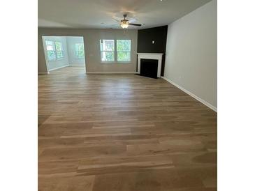 Spacious living room features hardwood floors, natural light, and a cozy fireplace at 2108 Amaryllis Dr, Grayson, GA 30017