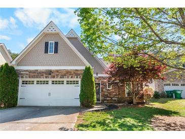 Charming home featuring a stone facade, two-car garage, and well-manicured lawn at 207 Cole Ct, Canton, GA 30114