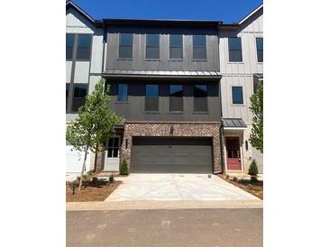 Modern townhome featuring a two-car garage, brick facade, and a neutral color palette at 445 Firefly Cir # 40, Alpharetta, GA 30009