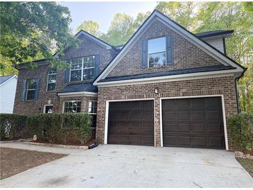Charming two-story brick home with a two-car garage and well-maintained landscaping at 5789 Star Flower Dr, Ellenwood, GA 30294