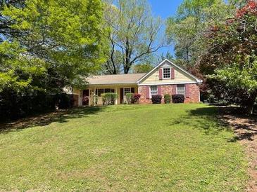 Charming single-Gathering home featuring a well-manicured lawn and mature trees at 1150 Orchard Way, Roswell, GA 30075