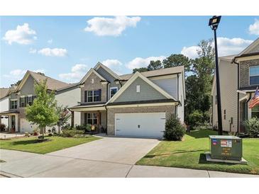 Charming two-story home with a brick facade, well-manicured lawn, and a two-car garage on a sunny day at 160 Avery Landing Way, Canton, GA 30115