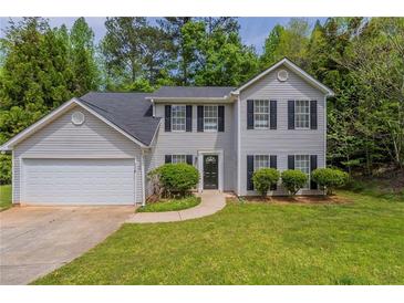 Charming two-story home featuring a well-manicured lawn and attached two-car garage at 6205 Leverett Dr, Lithonia, GA 30038