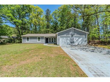 Charming one-story home featuring a two-car garage and a well-maintained front yard at 1665 Dunbarton Dr, Lithonia, GA 30058