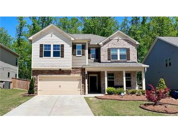 Charming two-story home featuring a brick and siding facade, manicured lawn, and a two-car garage at 1835 Wellston Dr, Lawrenceville, GA 30043