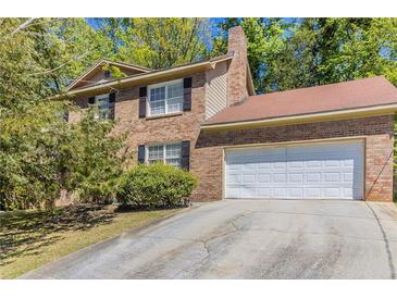 Charming brick two-story home with an attached two-car garage and a driveway at 6330 Phillips Pl, Lithonia, GA 30058