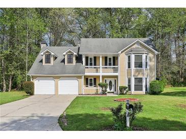 Charming two-story home featuring a welcoming front porch and well-manicured lawn at 3479 Portsmouth Cir, Lithonia, GA 30038