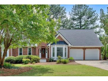 Charming brick home with well-maintained lawn, mature trees, and two-car garage at 4508 Club House Dr, Marietta, GA 30066