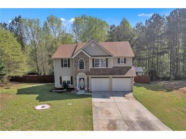 Two-story home with stone accents, attached two-car garage and well-manicured front lawn at 7228 Silverleaf Cir, Fairburn, GA 30213