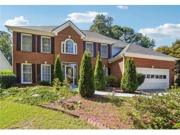Charming two-story brick home featuring a well-manicured lawn and an attached two-car garage at 1490 Rivershyre Pkwy, Lawrenceville, GA 30043