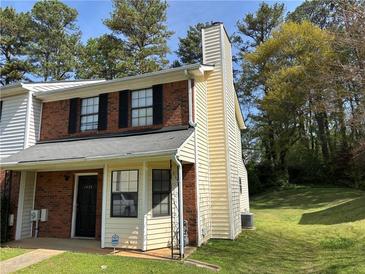 Charming two-story townhome with brick accents and a well-maintained front lawn at 1477 Springleaf Se Cir, Smyrna, GA 30080