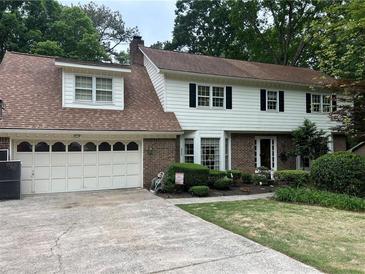 Charming two-story home with white siding, brick accents, and a well-maintained front yard and two-car attached garage at 3798 Lee Ridge Sw Way, Lilburn, GA 30047
