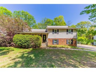 Charming two-story home featuring brick and siding with black shutters, a lawn and mature trees at 4170 N Quail N Dr, Douglasville, GA 30135