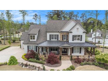 Stunning two-story home boasting a welcoming front porch, beautiful landscaping, and a charming white and stone facade at 3039 Malbec Vly, Acworth, GA 30101