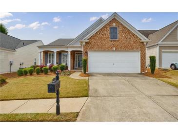 Charming brick home featuring a two-car garage, manicured lawn, and inviting front porch at 4265 Prince Charles Dr, Duluth, GA 30097