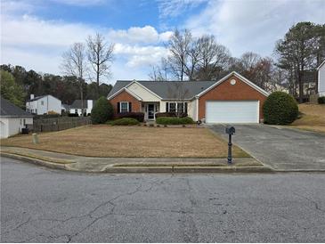 Charming single-story home featuring brick accents, manicured landscaping, and an attached two-car garage at 1235 Jasmine Green Ct, Dacula, GA 30019