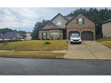 Charming two-story brick home with a well-manicured lawn and two-car garage at 1750 Stone Meadow Rd, Lithonia, GA 30058