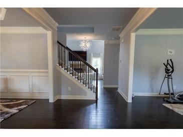 Spacious entryway featuring hardwood floors, staircase, and decorative chandelier leading into the living spaces at 552 Warrenton Run Dr, Sugar Hill, GA 30518