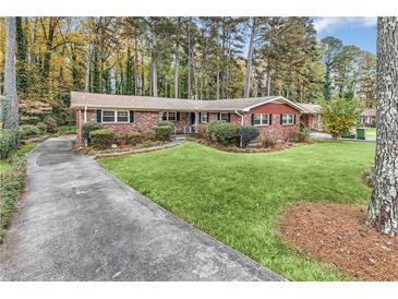Charming brick home boasts a well-manicured lawn and a long driveway leading to the front entrance at 1868 Fort Valley Sw Dr, Atlanta, GA 30311
