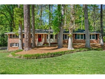 Charming single-story brick home featuring a red front door and mature trees in a landscaped yard at 2799 Briarglen Dr, Atlanta, GA 30340