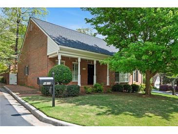 Charming brick home featuring a manicured lawn and inviting front porch with white columns at 1817 Bedfordshire Dr, Decatur, GA 30033