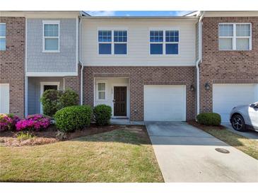 Charming townhome with brick facade, attached garage, and well-maintained landscaping at 1929 Millstream Holw, Conyers, GA 30012