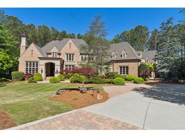 Stunning brick home with meticulously landscaped front yard and a circular driveway at 811 Flathead Pass, Suwanee, GA 30024