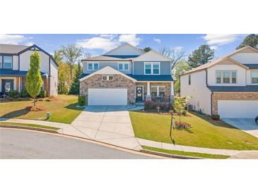 Beautiful two-story home with a stone facade, well-manicured lawn, and a two-car garage at 6070 Arbor Green Cir, Sugar Hill, GA 30518