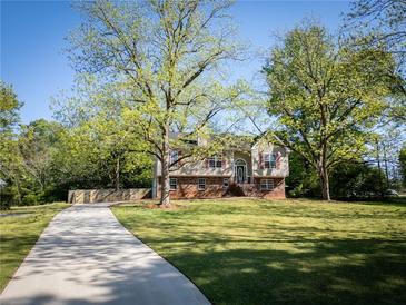 Charming split-level home featuring a well-manicured lawn, mature trees, and a long driveway at 20 Old Oak Ct, Covington, GA 30016
