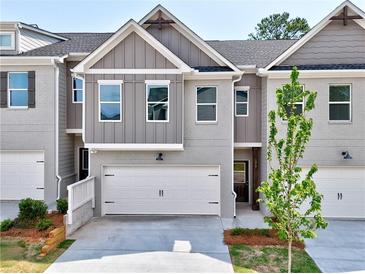 Charming townhome featuring gray brick, a two-car garage and a well-manicured front yard at 1217 Fern Ridge Ct # 16, Norcross, GA 30093
