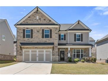 Charming two-story home with a stone and siding exterior, a well-manicured lawn, and a two-car garage at 1602 Dover Creek Ln, Lawrenceville, GA 30045