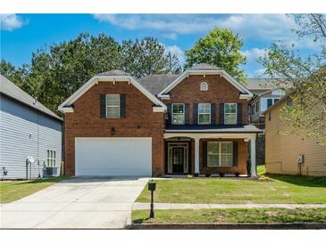 Beautiful two-story brick home with a manicured lawn, two-car garage, and inviting front porch at 351 Chandler Bluff Ct, Grayson, GA 30017