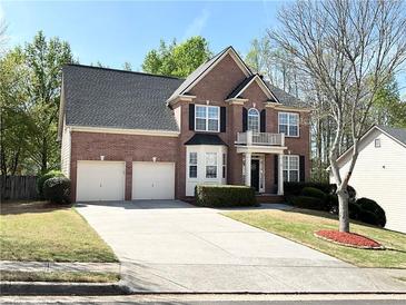 Charming two-story brick home with a two-car garage, black shutters, and well-manicured landscaping at 2585 Chandler Grove Dr, Buford, GA 30519